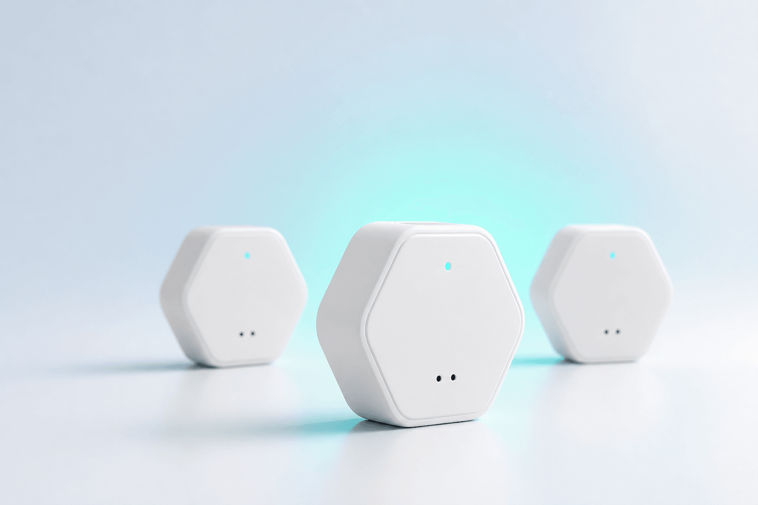 Three tiny white Air Sensei environmental sensors with rounded hexagonal edges